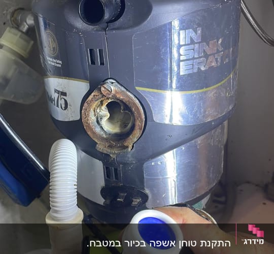יד מחזיקה צינור מתחת לכיור עם מסנן מים